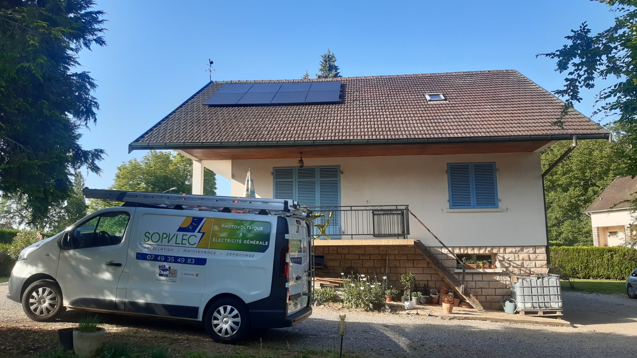 Véhicule SOPVLEC devant une maison équipée de panneaux solaires